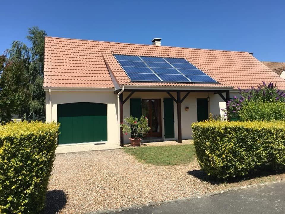 Rénovation de façade peinte sur maison avec garage et volets verts