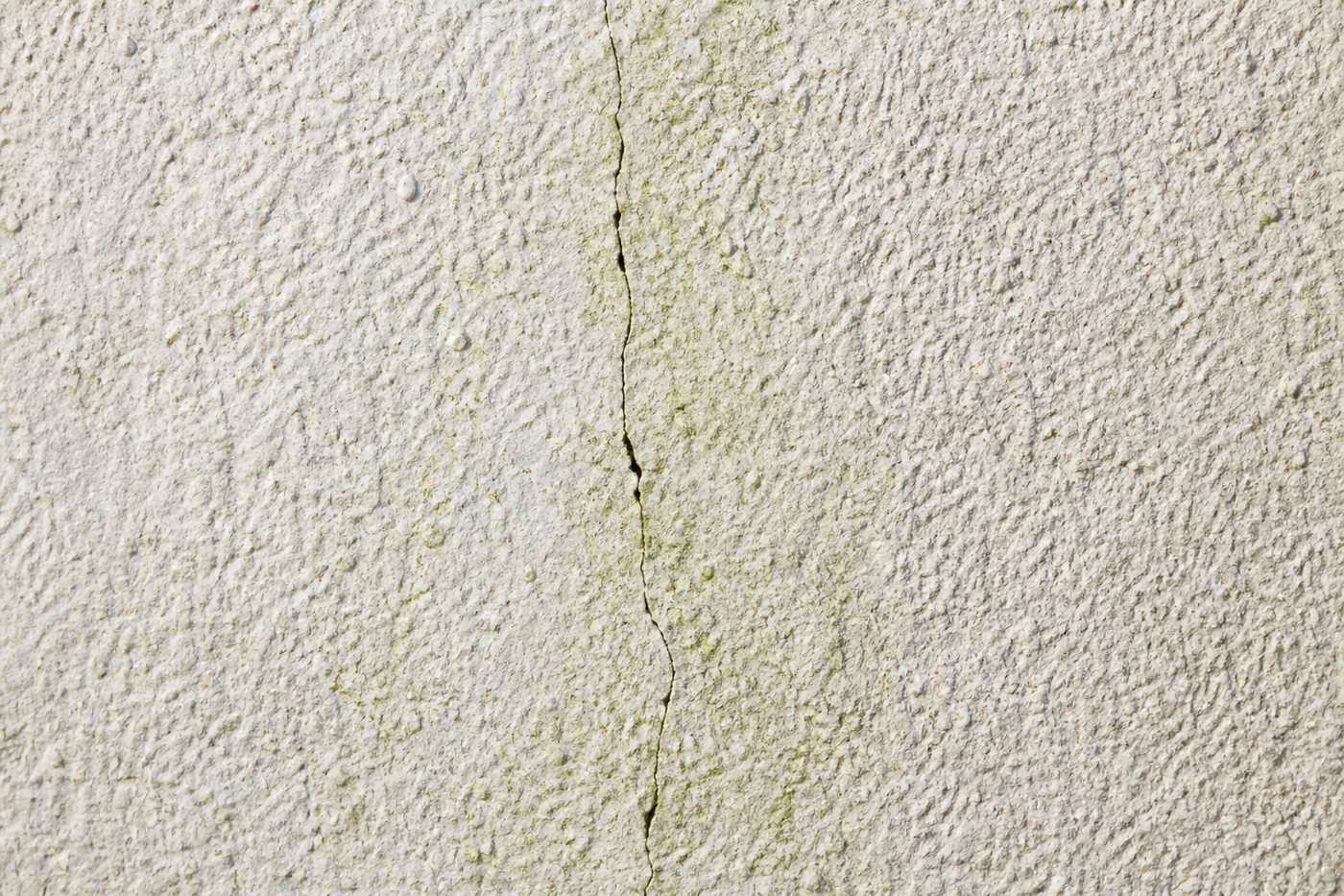Micro-fissure dans un enduit de façade, vue rapprochée